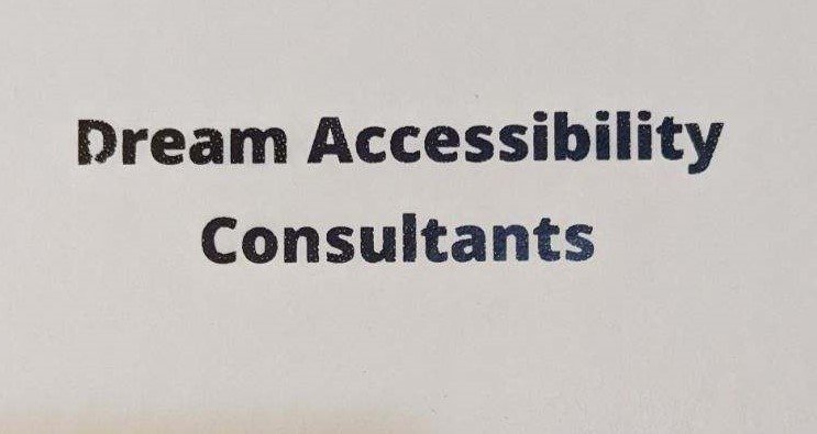  A white notebook with bold black letters that say, Dream Accessibility Consultants.